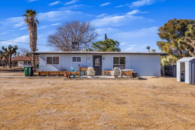 back of property featuring a storage unit