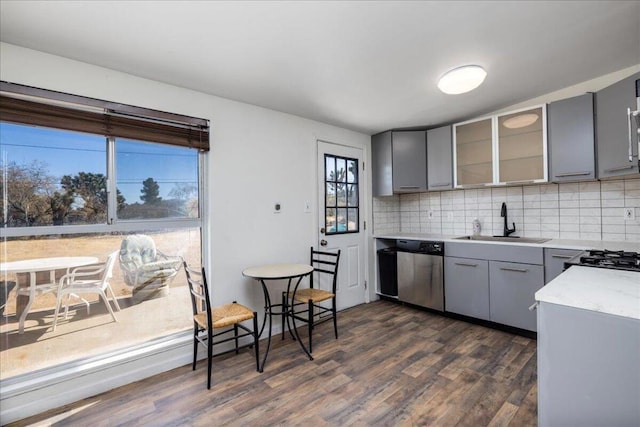 kitchen with stainless steel dishwasher, gray cabinets, sink, and dark wood-type flooring