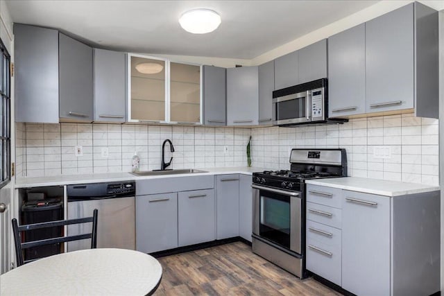 kitchen with gray cabinets, sink, appliances with stainless steel finishes, and dark wood-type flooring