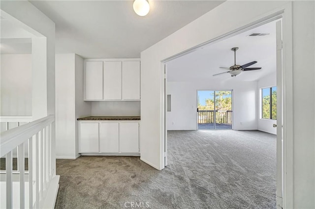 empty room with a ceiling fan, light carpet, visible vents, and baseboards