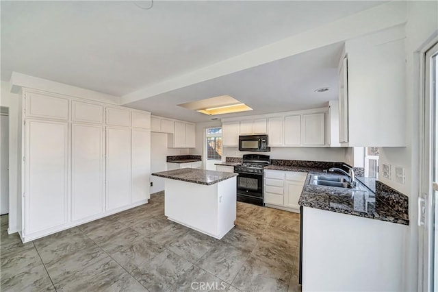 kitchen featuring dark stone countertops, white cabinets, a sink, and black appliances