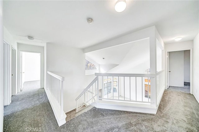 hallway with carpet and an upstairs landing