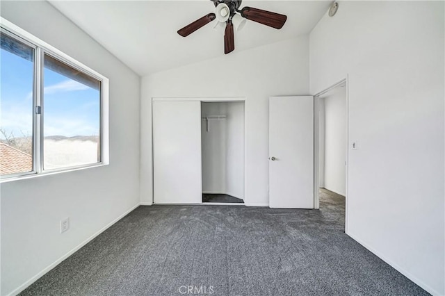 unfurnished bedroom featuring lofted ceiling, a closet, carpet flooring, and ceiling fan