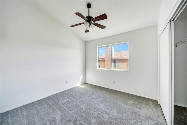 unfurnished bedroom with ceiling fan, a closet, carpet floors, and vaulted ceiling