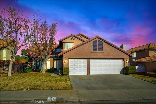 view of front of home featuring a garage and a yard