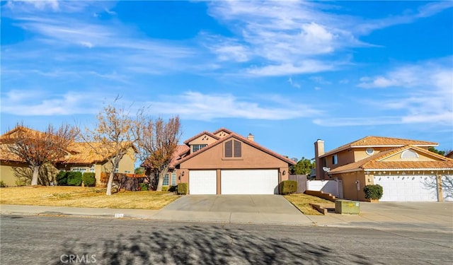 view of front of house featuring a garage, fence, concrete driveway, a tiled roof, and stucco siding