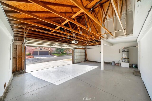 garage with strapped water heater and a garage door opener