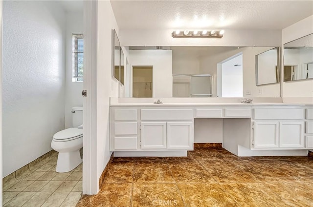 full bathroom featuring toilet, a shower with door, and vanity