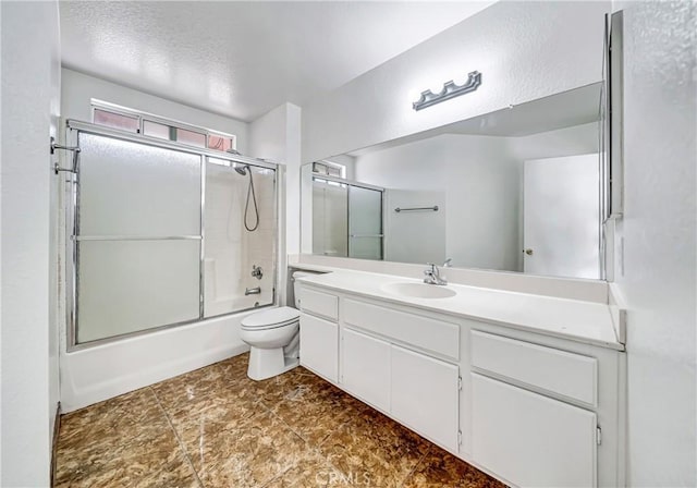 bathroom with vanity, toilet, and bath / shower combo with glass door