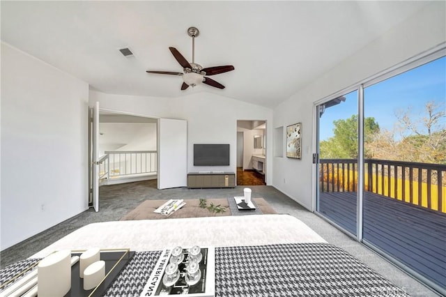 unfurnished living room with carpet floors, visible vents, vaulted ceiling, and a ceiling fan