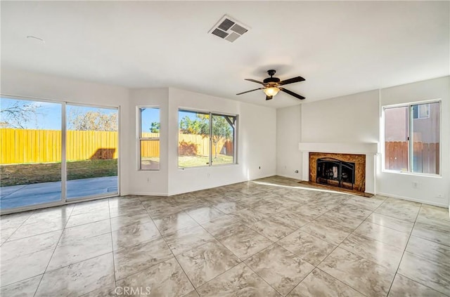 unfurnished living room with ceiling fan and a healthy amount of sunlight