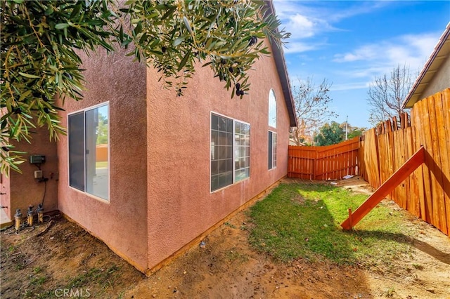 view of property exterior with fence private yard and stucco siding