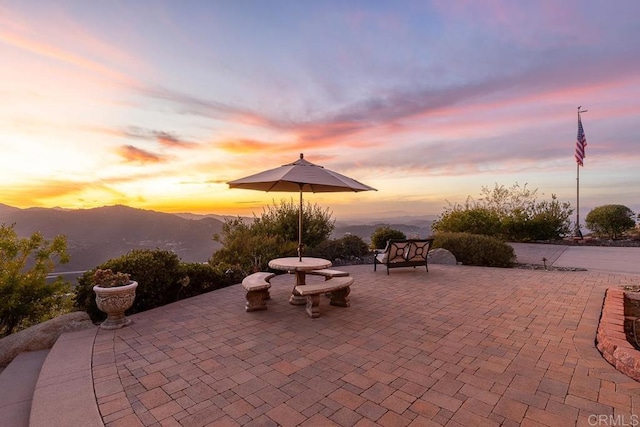 patio terrace at dusk featuring a mountain view