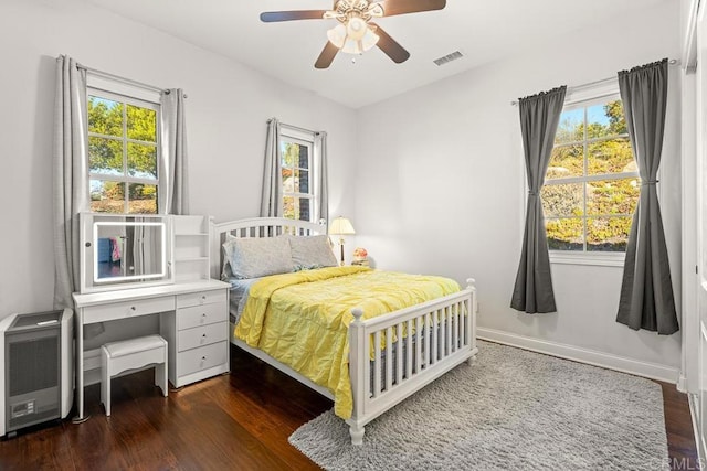 bedroom featuring dark wood-type flooring, ceiling fan, and heating unit