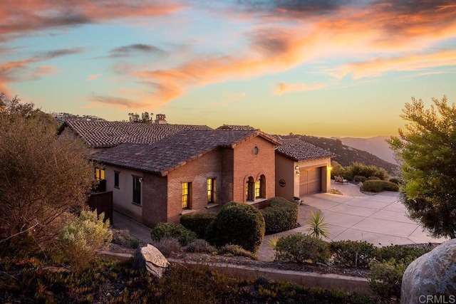 property exterior at dusk with a mountain view and a garage