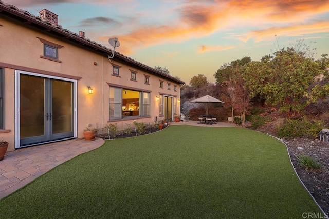 yard at dusk with a patio area