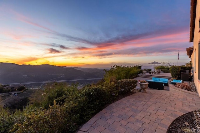 patio terrace at dusk with an outdoor hangout area and a mountain view