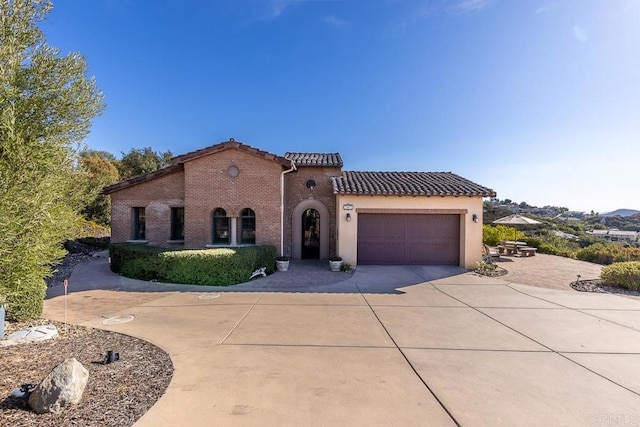 mediterranean / spanish-style home with a garage