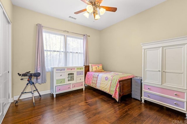 bedroom with ceiling fan, dark wood-type flooring, and a closet