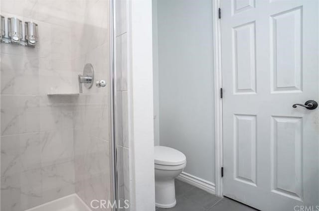 full bath featuring tile patterned flooring, a shower stall, and toilet