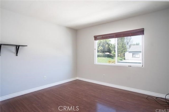 empty room featuring baseboards and wood finished floors