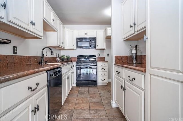 kitchen featuring dark countertops, black appliances, white cabinetry, and a sink