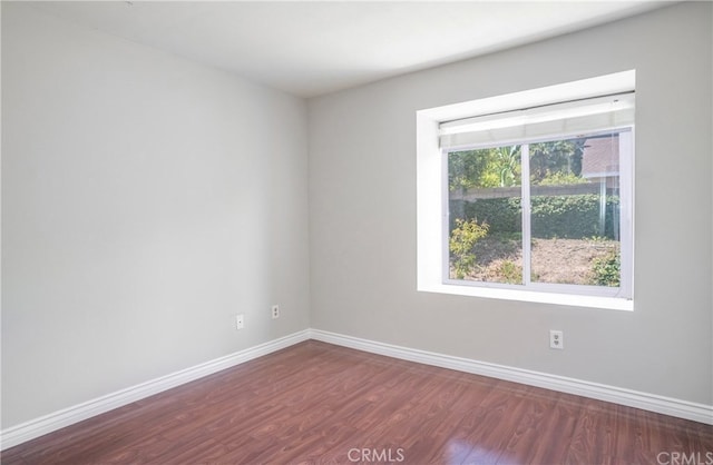 unfurnished room with wood finished floors and baseboards