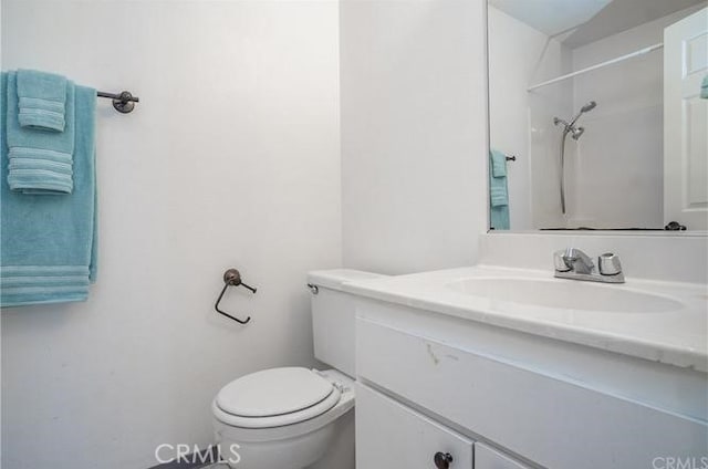 full bathroom featuring toilet, a shower, and vanity