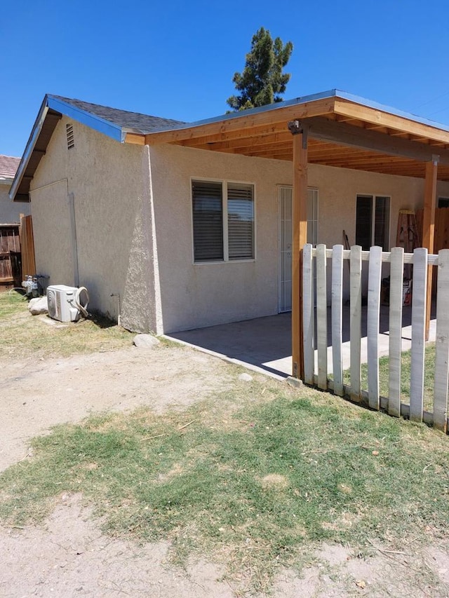 back of property with ac unit and a patio