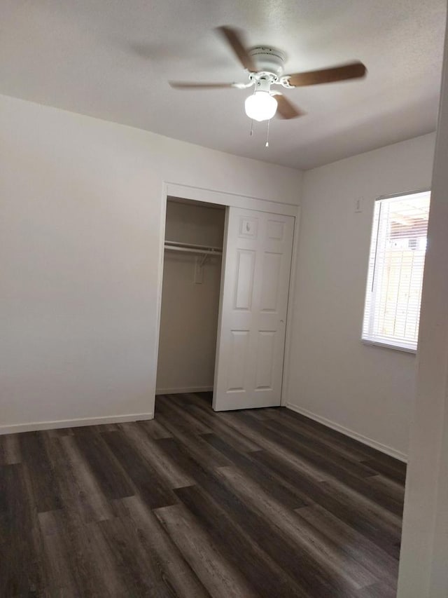 unfurnished bedroom with ceiling fan, a closet, and dark hardwood / wood-style floors