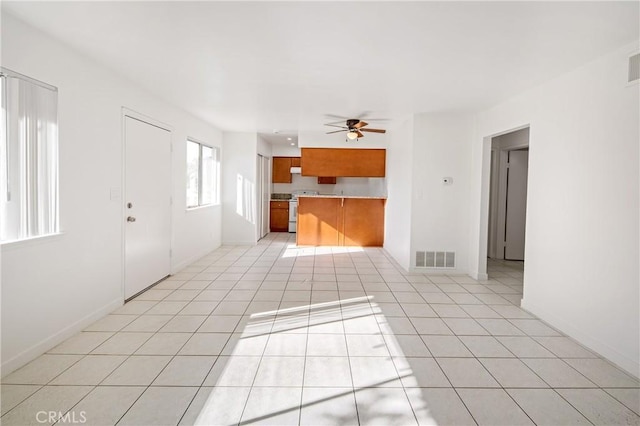 unfurnished living room with light tile patterned floors and ceiling fan