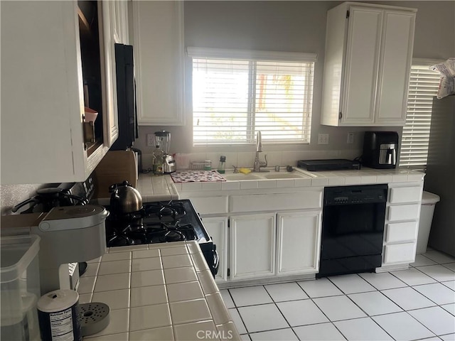 kitchen with white cabinets, sink, tile counters, and black appliances