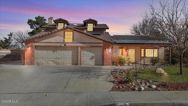 view of front of home featuring solar panels, a yard, and a garage