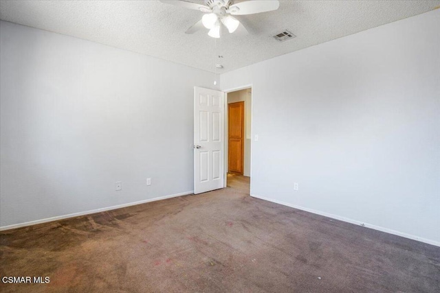 carpeted empty room with ceiling fan and a textured ceiling