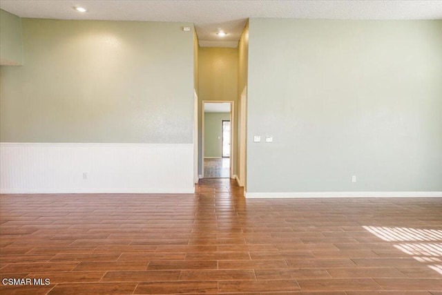 empty room featuring a textured ceiling and hardwood / wood-style flooring