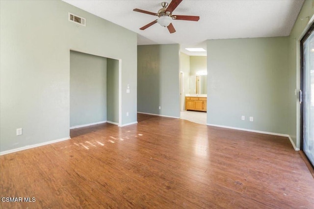 empty room with ceiling fan and light hardwood / wood-style floors