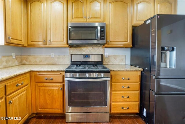 kitchen featuring backsplash, light stone counters, dark hardwood / wood-style flooring, and appliances with stainless steel finishes