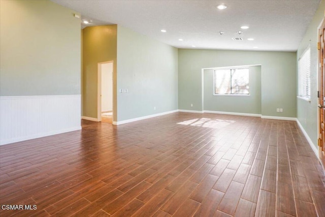 spare room with lofted ceiling and dark hardwood / wood-style floors