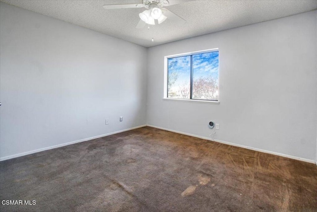 empty room with ceiling fan, dark carpet, and a textured ceiling