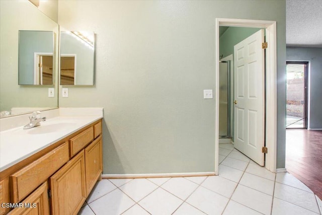 bathroom with tile patterned flooring, vanity, and a textured ceiling