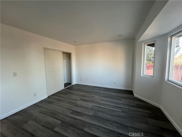 unfurnished bedroom featuring a closet and dark hardwood / wood-style flooring