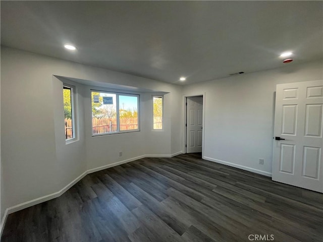 unfurnished room with dark hardwood / wood-style flooring