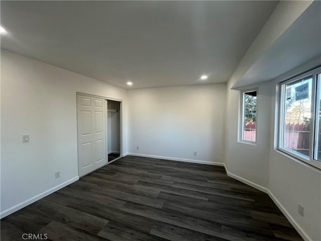 unfurnished bedroom with a closet and dark hardwood / wood-style floors