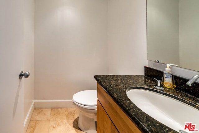 bathroom featuring tile patterned flooring, vanity, and toilet