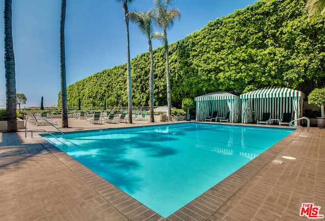 view of swimming pool featuring a patio area and a mountain view