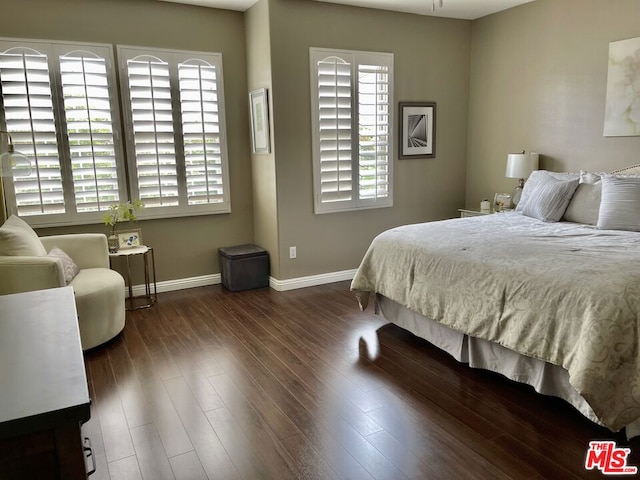 bedroom with dark hardwood / wood-style floors and multiple windows