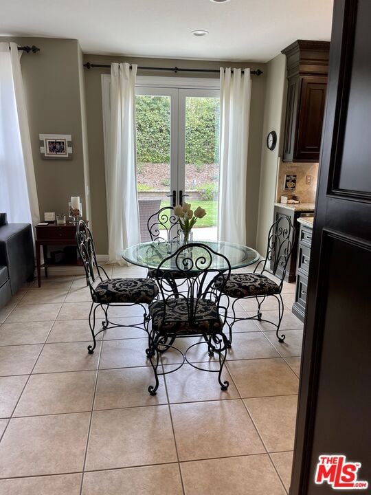 tiled dining space featuring french doors