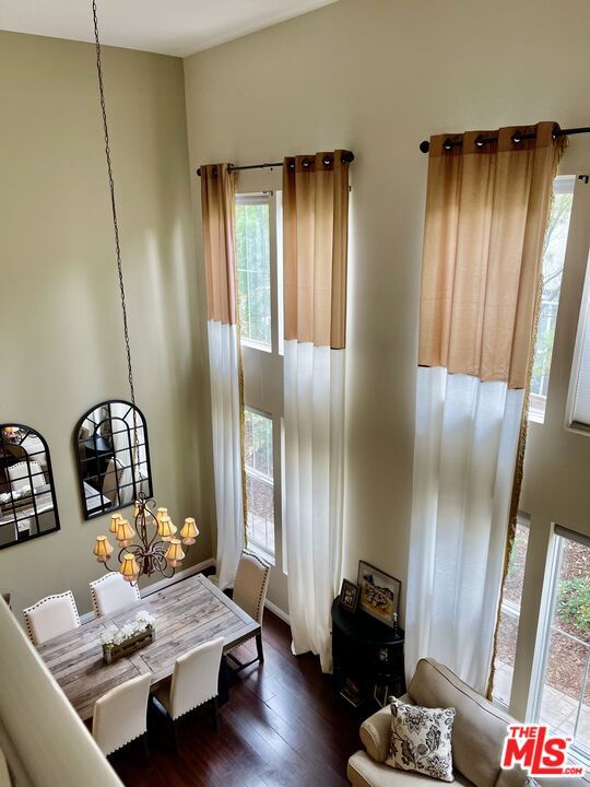 dining space with dark hardwood / wood-style floors and a notable chandelier