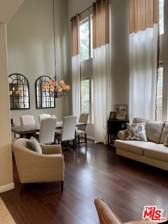 living room featuring dark hardwood / wood-style floors, a high ceiling, and a notable chandelier