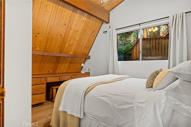 bedroom with hardwood / wood-style flooring, built in desk, wood ceiling, and lofted ceiling with beams